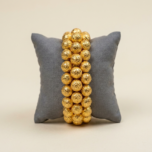 Pohchi bangle, gold bead collar around a cushion, front view